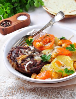 Patates, nohut, havuç, domates, soğan ve kimyon ile kuzu kızartma