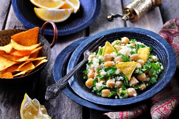 Kikärt sallad med couscous, persilja, olivolja och tortillachips. — Stockfoto