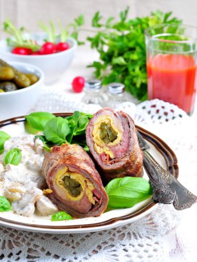 Nağmeleme domuz pastırması ile doldurulmuş sığır eti pişmiş yumurta, ekşi krema demlenmiş mantar ile süslenmiş salatalık turşusu.