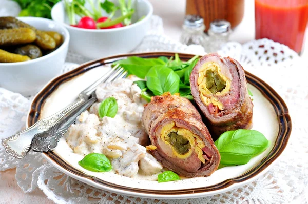 Roulade of beef stuffed with bacon, scrambled eggs, pickled cucumbers garnished with mushrooms stewed in sour cream. — Stock Photo, Image