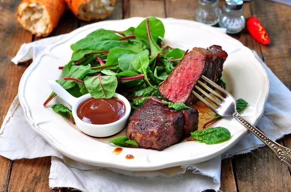 Medium steak with salad and barbecue sauce — Stock Photo, Image