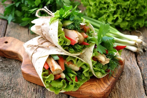 Rolo de tortilla com frango grelhado, tomate, pepino, pimentão, alface . — Fotografia de Stock