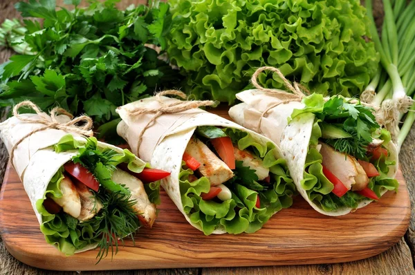 Rolo de tortilla com frango grelhado, tomate, pepino, pimentão, alface . — Fotografia de Stock