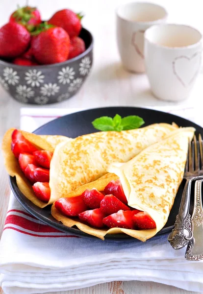 Panquecas com morangos orgânicos, caramelo, canela e hortelã . — Fotografia de Stock