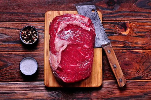 Bife de costela de carne crua em uma tábua de corte de bambu em fundo de madeira . — Fotografia de Stock