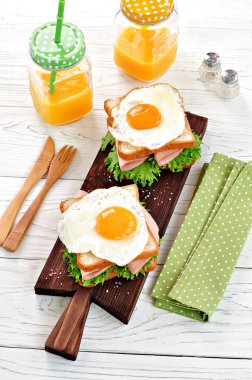 Jambon, marul ve kızarmış yumurta ile sandviç. Kahvaltı.