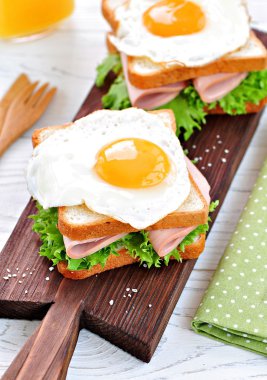 Jambon, marul ve kızarmış yumurta ile sandviç. Kahvaltı.