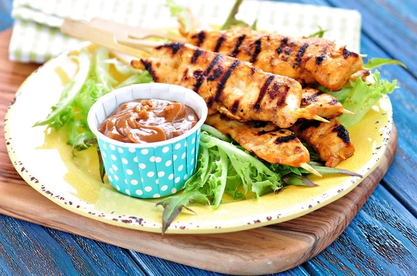 Zelfgemaakte kip kebab op houten spiesen met sla en pindasaus — Stockfoto