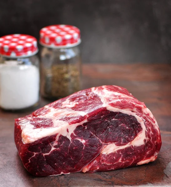 Bife de ribeye cru com sal marinho e tomilho seco em uma placa de granito . — Fotografia de Stock