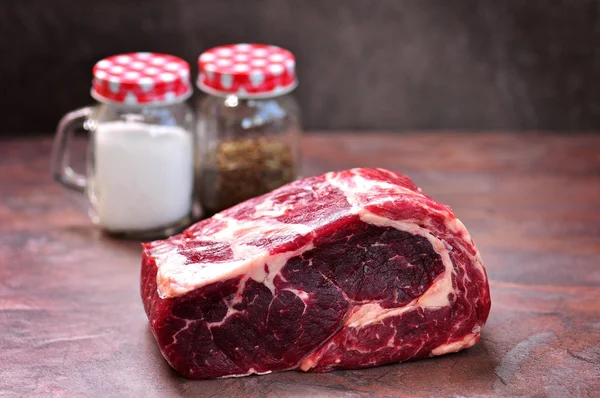 Deniz tuz ve kurutulmuş kekik bir granit kurulu ham antrikot biftek.