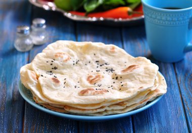 Ev yapımı ekmek pide üzerinde mavi bir arka plan.
