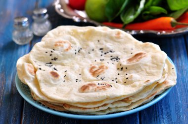 Ev yapımı ekmek pide üzerinde mavi bir arka plan.