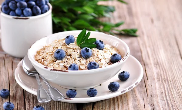 Oat flakes Quick cooking with blueberries. Healthy breakfast. — Stock Photo, Image