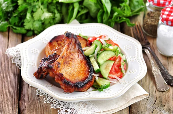 Grilled Pork chop with salad of tomatoes, cucumbers, onions, parsley and olive oil. — Stock Photo, Image