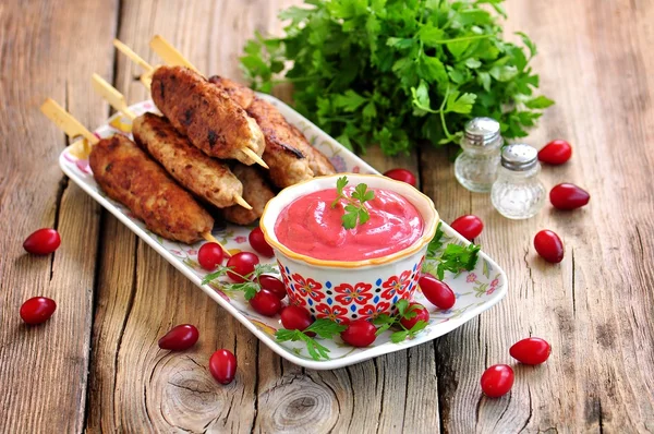 Hausgemachte Sauce Hahnenbeere mit Fleischspießen auf Holzspießen. — Stockfoto