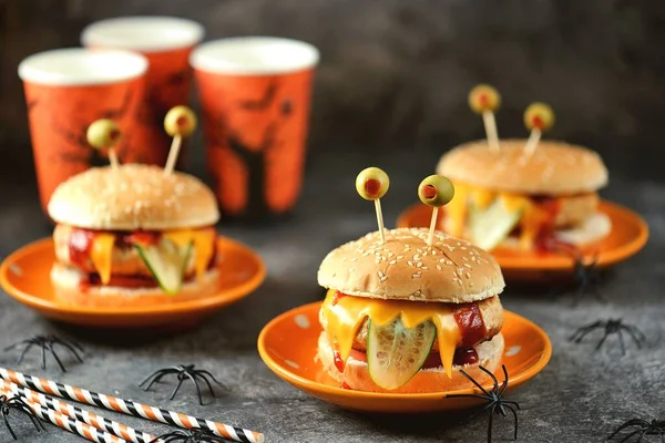 Funny monster burgers with chicken, tomato, cucumber, toast cheese and olive eyes. Food for Halloween.