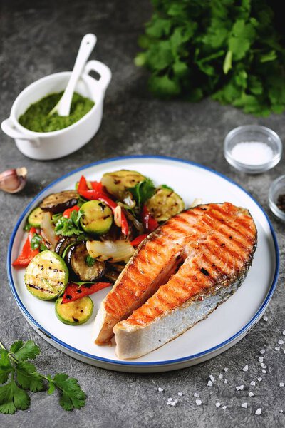 Grilled salmon steak with grilled salad of zucchini, eggplant, bell peppers, onions, garlic, cilantro, olive oil and wine vinegar.