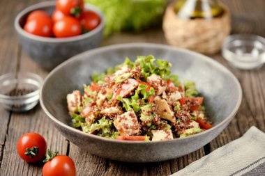 Sağlıklı kinoa salatası, kiraz domatesi, avokado, tavuk göğsü, marul ve limon suyuyla zeytinyağı sosu..