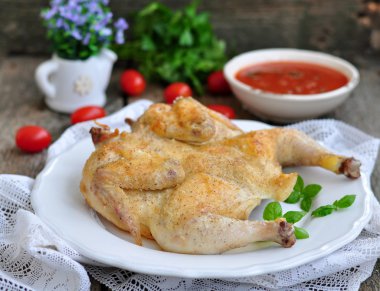 Ahşap bir masa üzerinde bir domates soslu ızgara tavuk