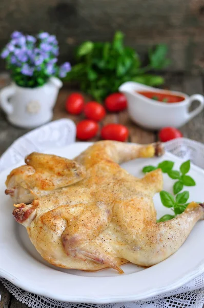 Grilled chicken with a tomato sauce on a wooden table — Stock Photo, Image