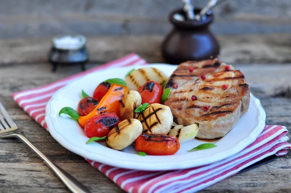 Viande et légumes grillés sur la table en bois — Photo