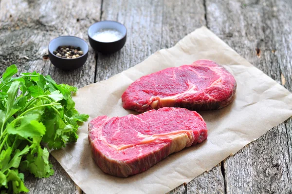 Steak de bœuf cru sur une table en bois — Photo
