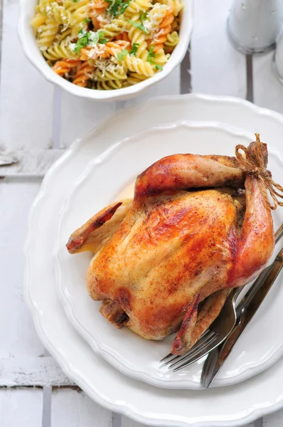 Gegrilltes Hühnchen mit Pasta und Basilikum auf einem weißen Holztisch — Stockfoto