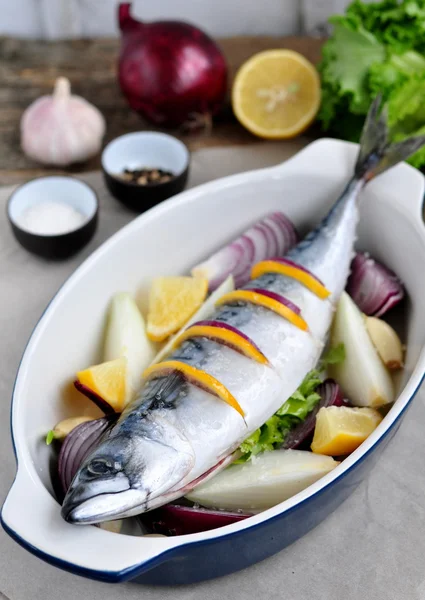 Fresh mackerel fish with a lemon, bow, salt and pepper on a wooden table — Stock Photo, Image