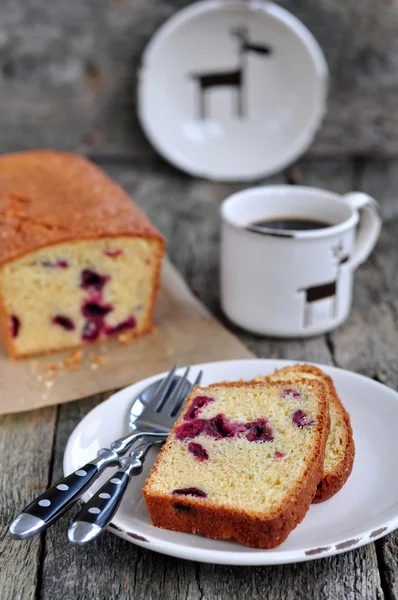 Xícara de café ou chá com um bolo de cereja em uma mesa de jantar de madeira — Fotografia de Stock