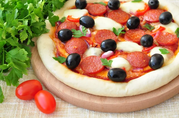 Pizza kézzel a szalámi, Mozzarella, olívabogyó, hagyma és paradicsomszósz — Stock Fotó