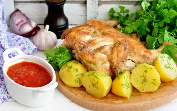 Grilovaná kuřata a vařenými brambory na dřevěný stůl — Stock fotografie