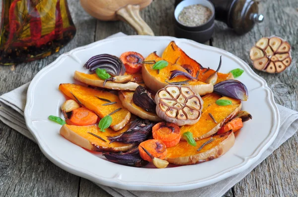 Calabaza al horno con una cebolla, zanahoria, ajo, romero, albahaca y sal rosa — Foto de Stock