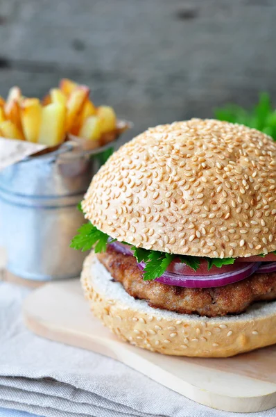 Closeup of home made burgers with the fried potato on wooden and linen background — Stock Photo, Image