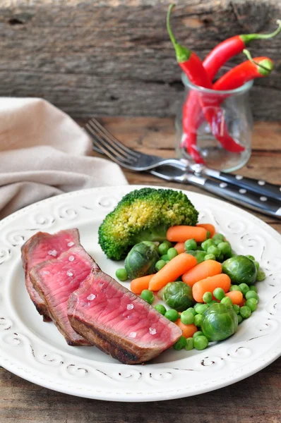 Juicy steak slices with a peas, broccoli and carrot — Stock Photo, Image