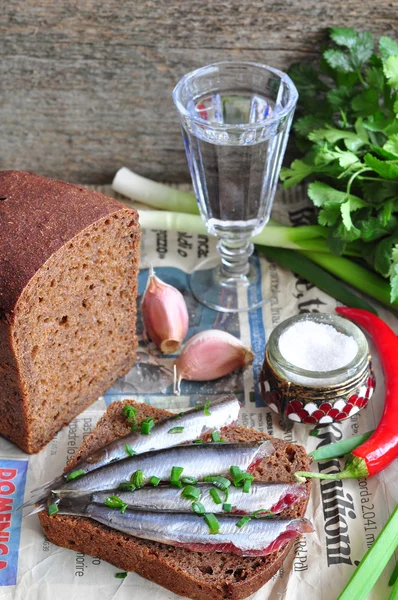 Russian traditions open sandwich with a sardines on rye bread with the wineglass of vodka — Stock Photo, Image