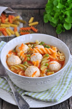 Köfte, makarna, bezelye ve ahşap bir masa üzerine maydanoz çorbası