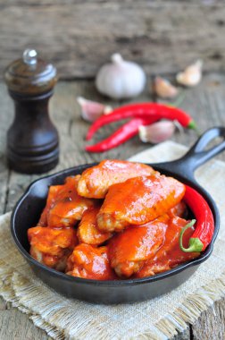 Sıcak tavuk kanatları Barbekü kara tencerede izole