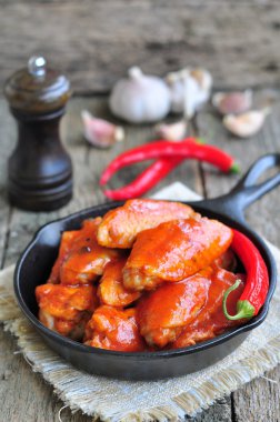 Sıcak tavuk kanatları Barbekü kara tencerede izole