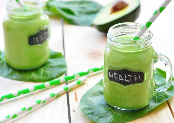 Green vegetable smoothie isolated on wood background