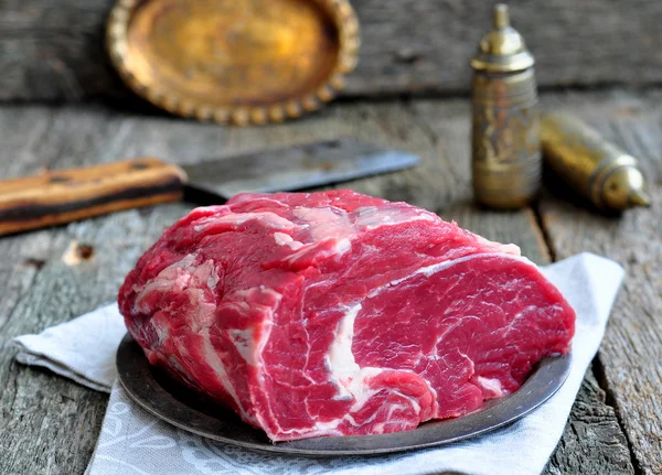 Bife de carne crua suculento na mesa de madeira — Fotografia de Stock