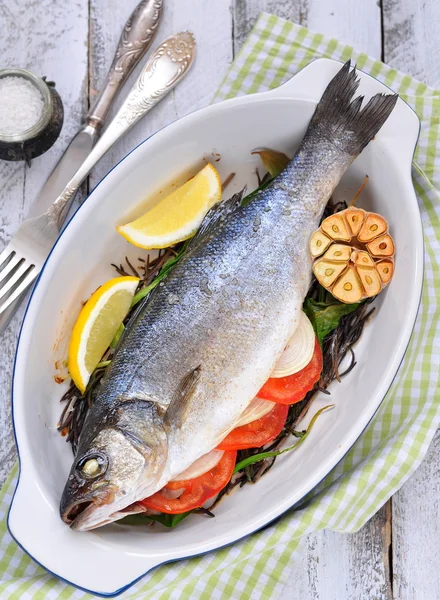 Baked fish with herbs, vegetables and garlic, selective focus — Stock Photo, Image