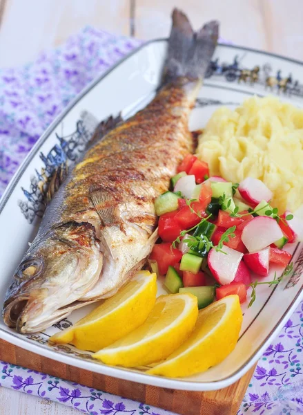 Жареная рыба с картофельным пюре, ломтиком лимона и салатом из овощей — стоковое фото