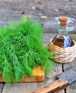 Ahşap bir masa üzerinde Zeytinyağlı taze dereotu demet