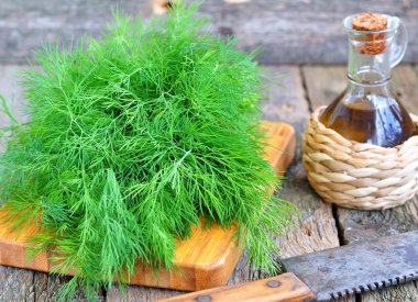 Ahşap bir masa üzerinde Zeytinyağlı taze dereotu demet