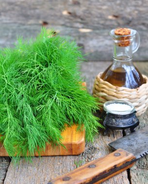 Ahşap bir masa üzerinde Zeytinyağlı taze dereotu demet