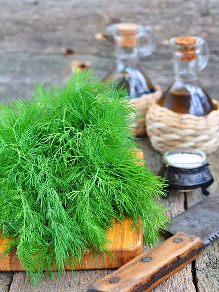 Ahşap bir masa üzerinde Zeytinyağlı taze dereotu demet