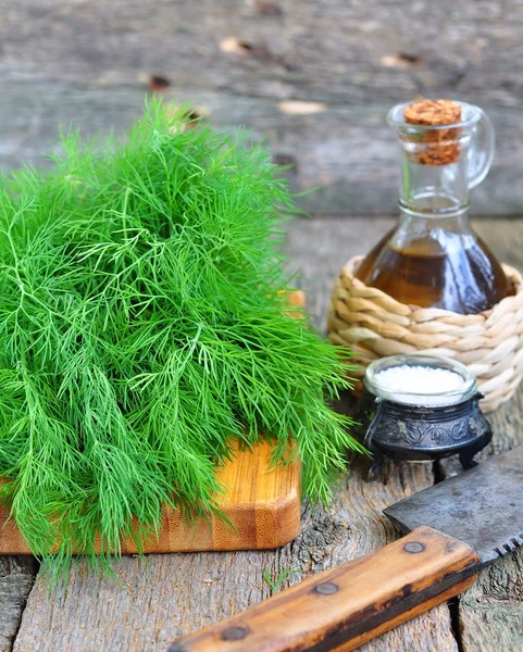 Ahşap bir masa üzerinde Zeytinyağlı taze dereotu demet