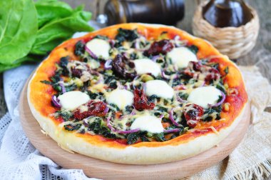 Kurutulmuş domates, ıspanak, soğan ve peynir vejetaryen pizza. seçici odak.