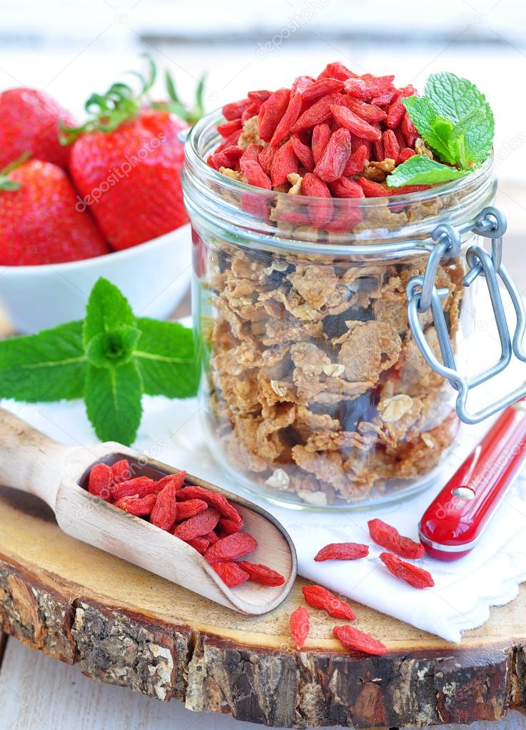 Muesli with dried goji berries and mint on a wooden backgraund