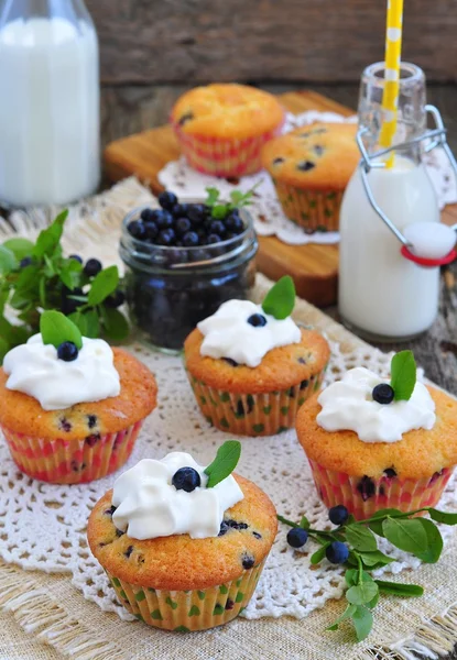 Muffins frescos com mirtilo e leite em fundo de madeira — Fotografia de Stock